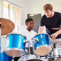 Boy playing drums in a classroom